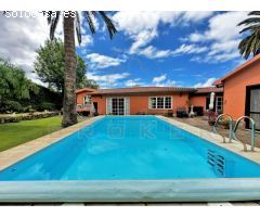 Chalet de una sola planta con amplio jardín y piscina en una zona residencial