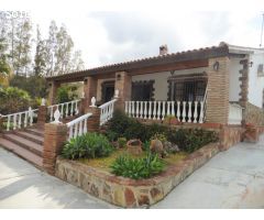 Chalet con porche, piscina y barbacoa.
