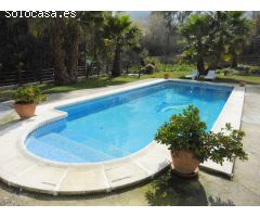 Chalet con porche, piscina y barbacoa.