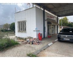 Terreno industrial en venta con edificio de gasolinera contruido en su interior.